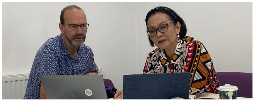 Two people looking at laptop screens together